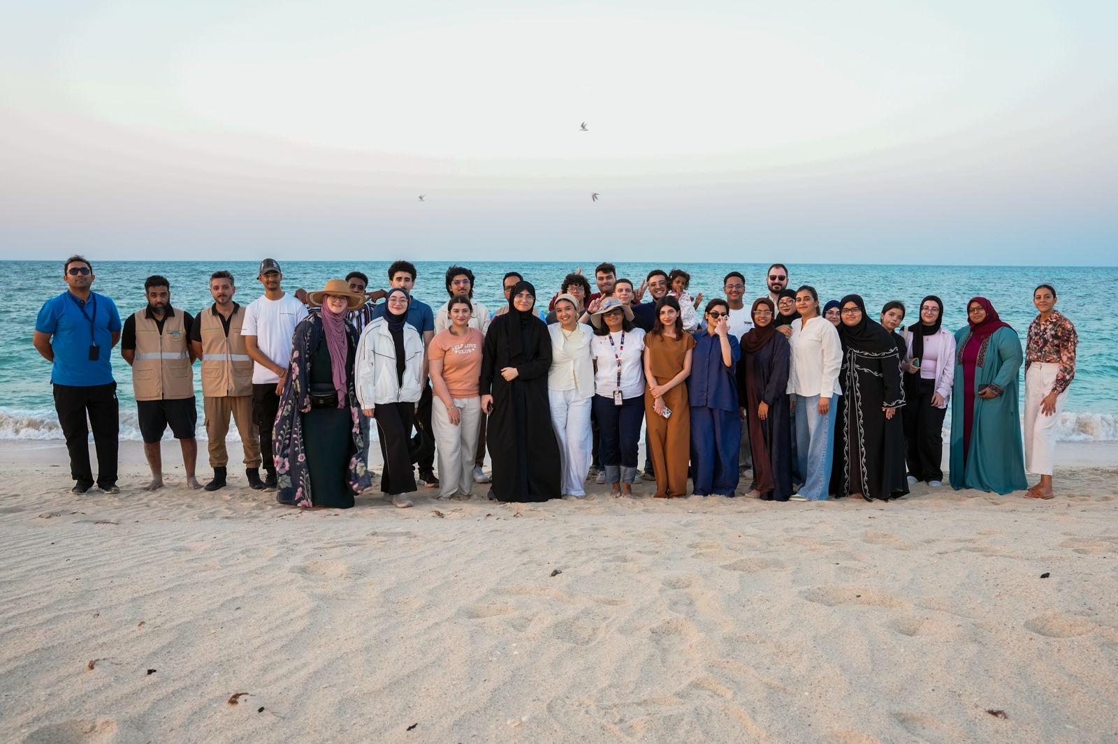 Group photo of Barzan University College students and conservation volunteers at Fuwairit Beach following a Hawksbill sea turtle conservation experience.